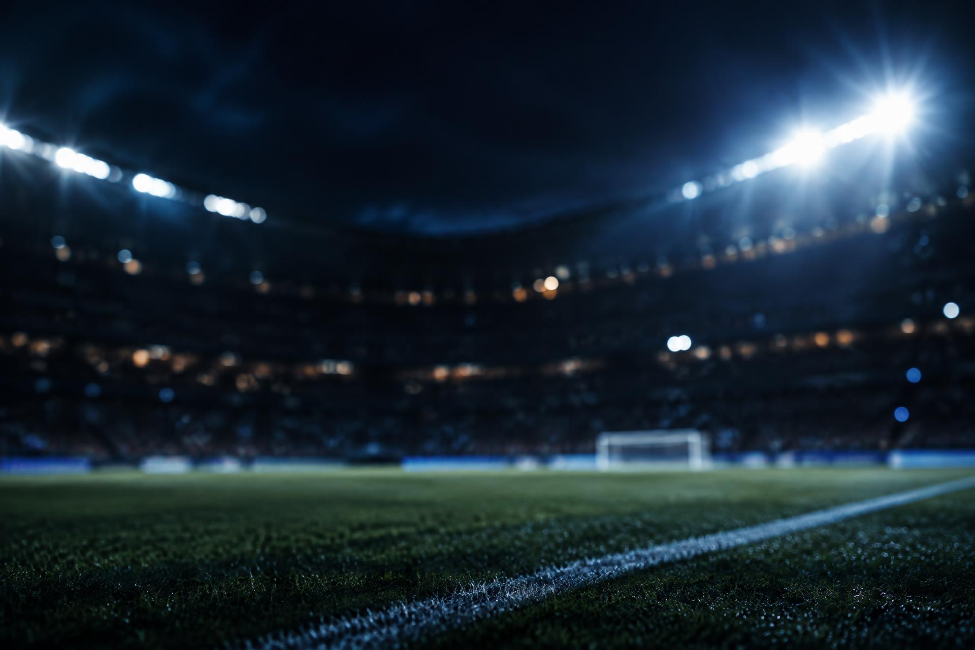 Pelouse d'un stade de football éclairée par les projecteurs la nuit